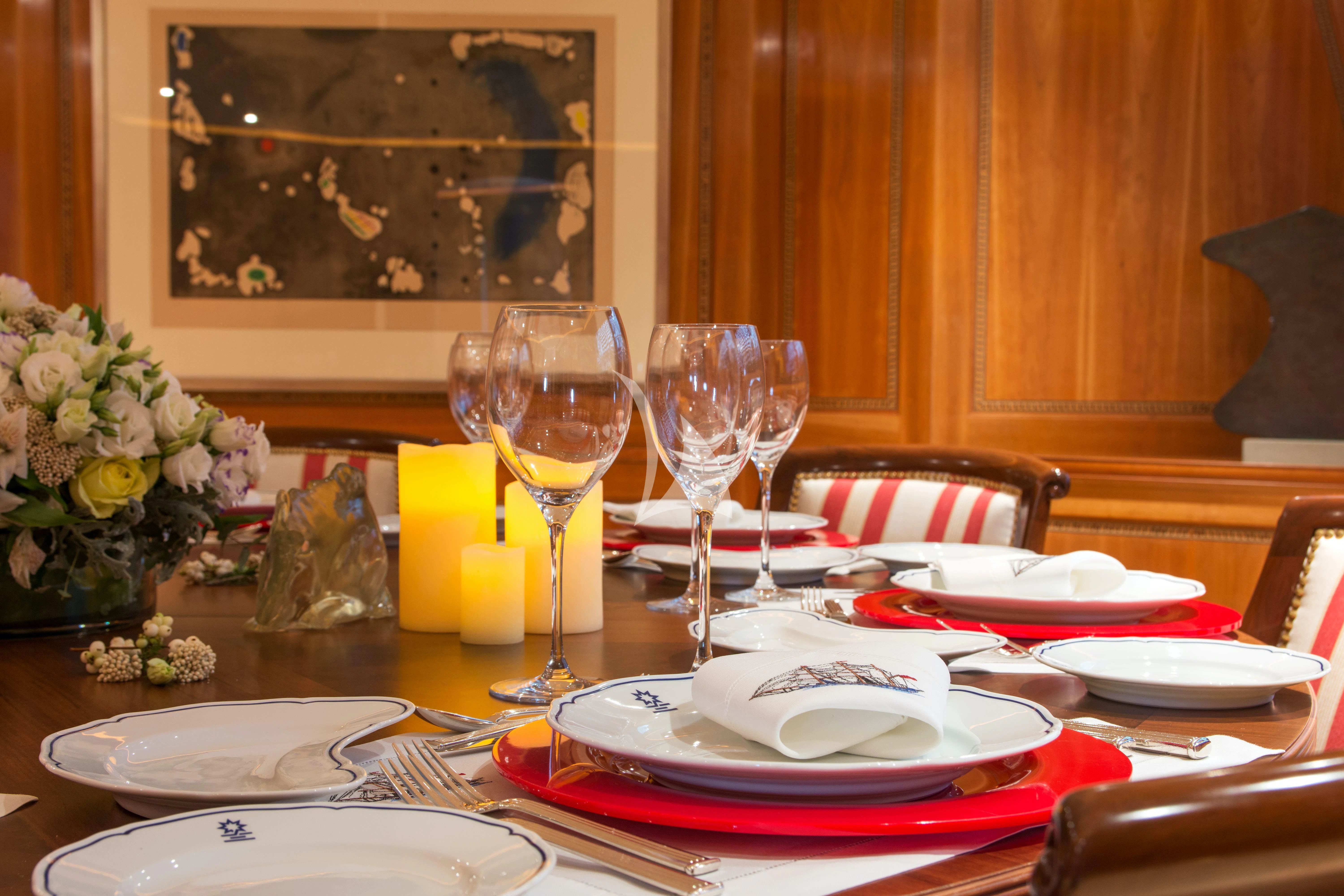 a table with plates and glasses aboard XASTERIA Yacht for Charter