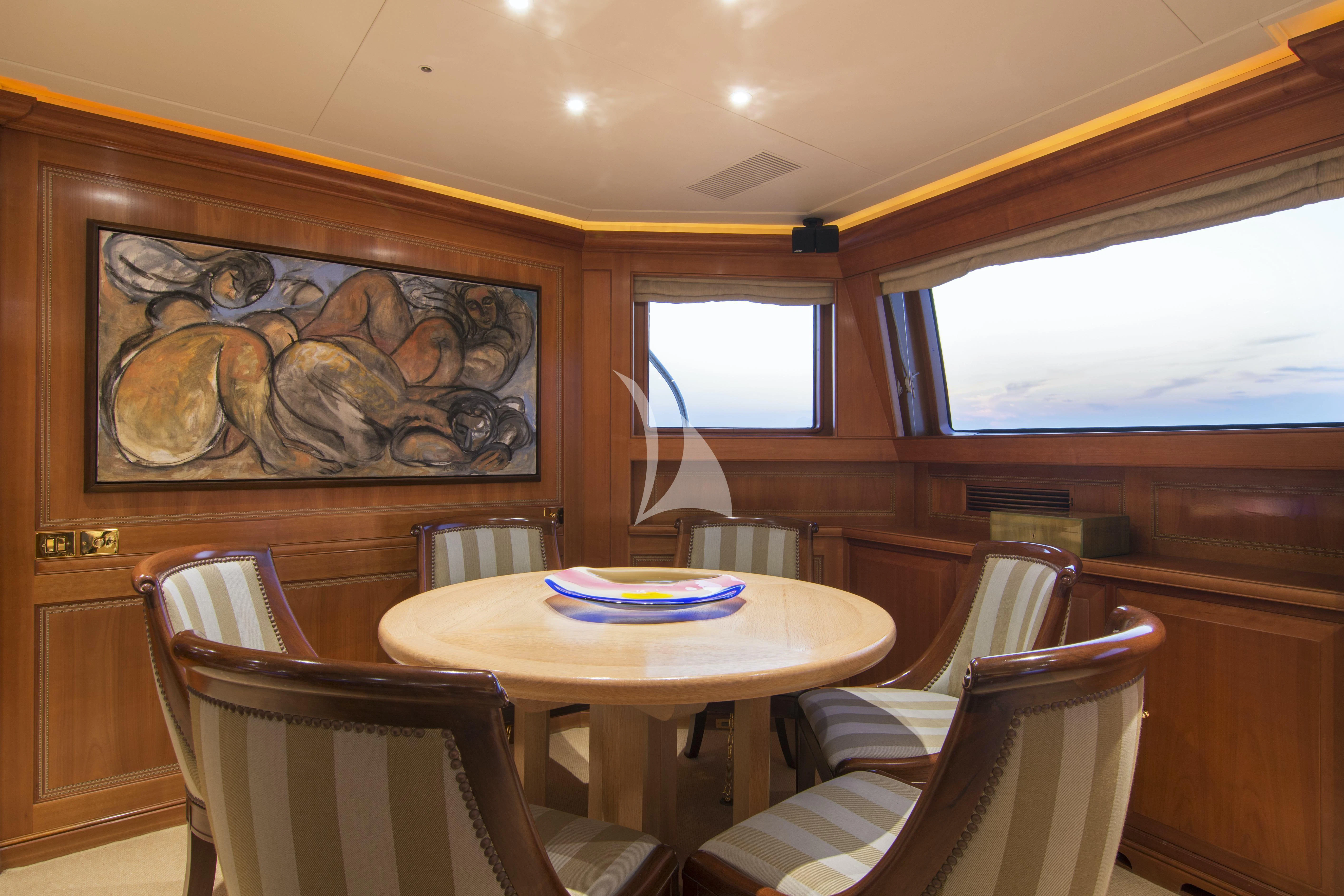 a dining table and chairs in a room with wood walls aboard XASTERIA Yacht for Charter