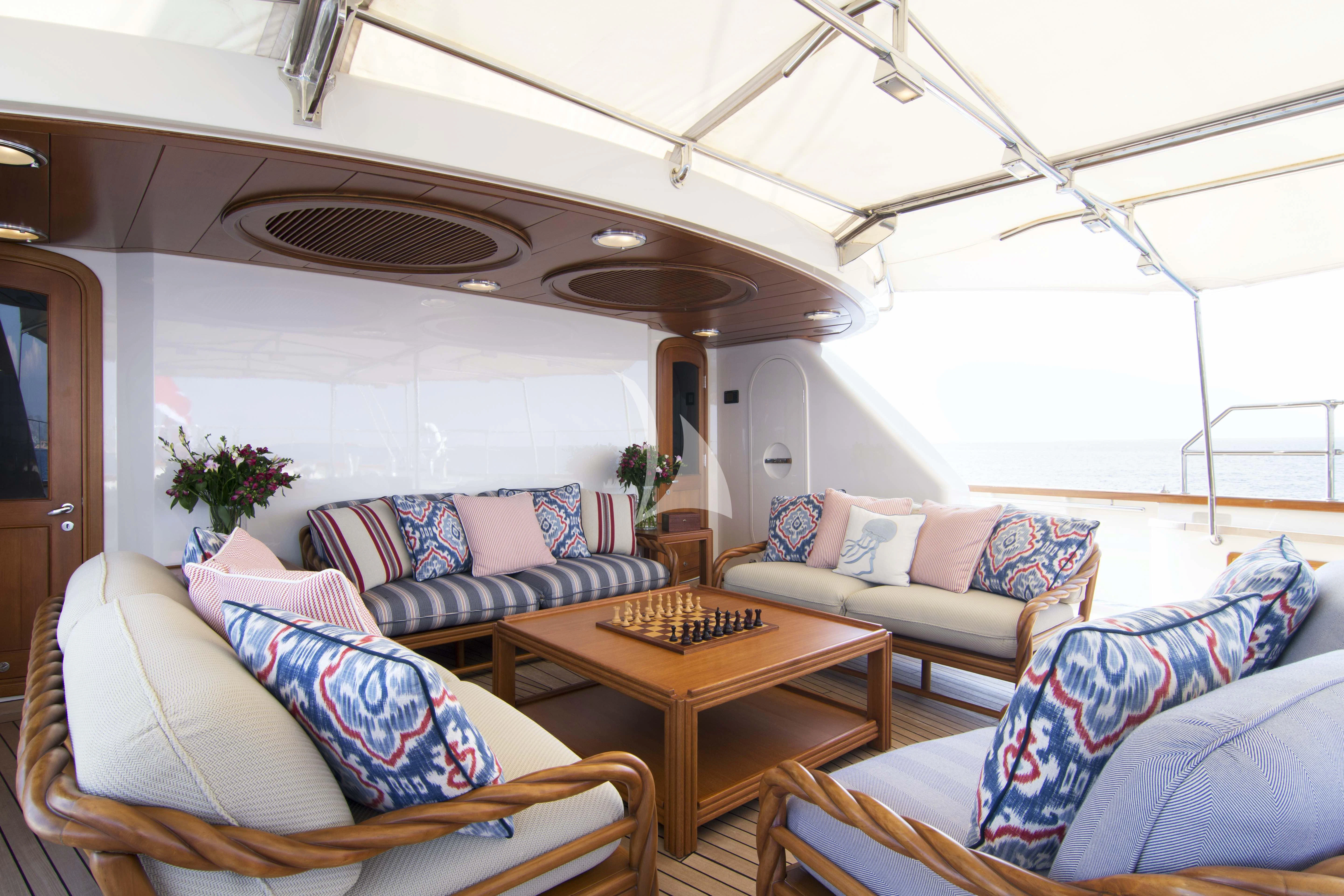 a living room with a table and couches aboard XASTERIA Yacht for Charter