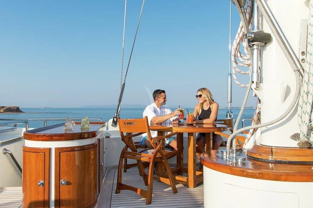 a couple sitting at a table on a boat aboard XASTERIA Yacht for Charter