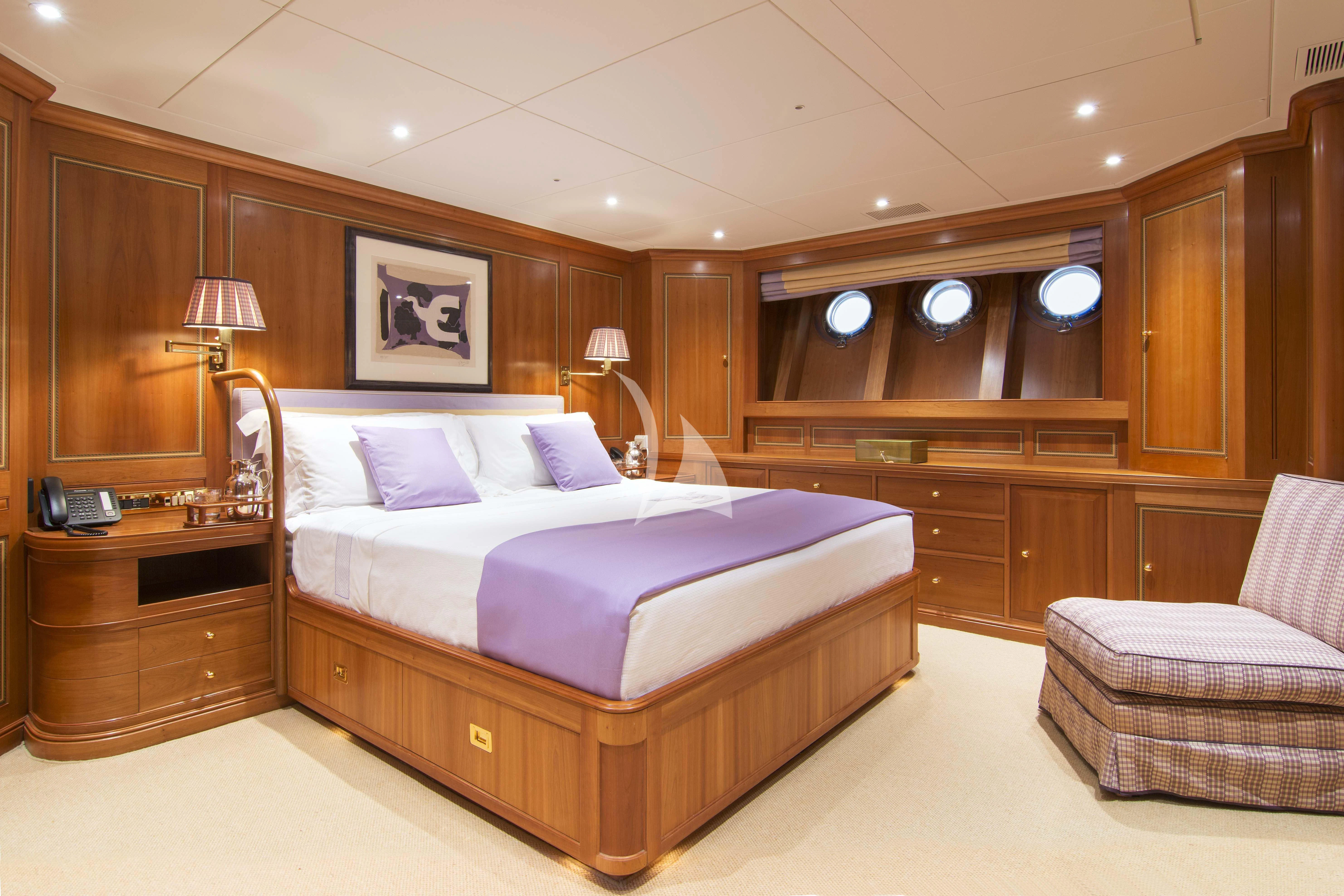 a bedroom with a bed and a chair aboard XASTERIA Yacht for Charter