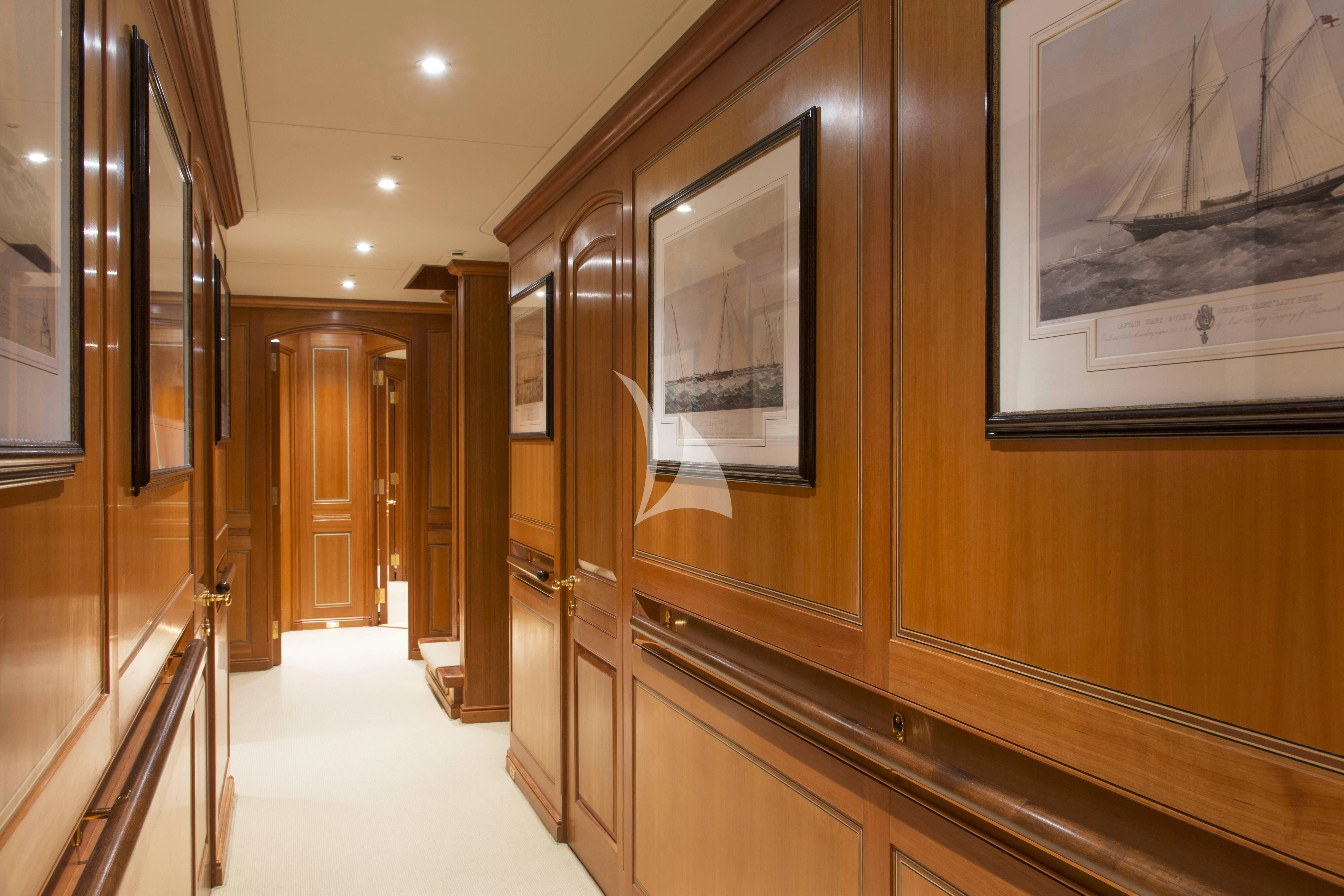 a hallway with paintings on the wall aboard XASTERIA Yacht for Charter