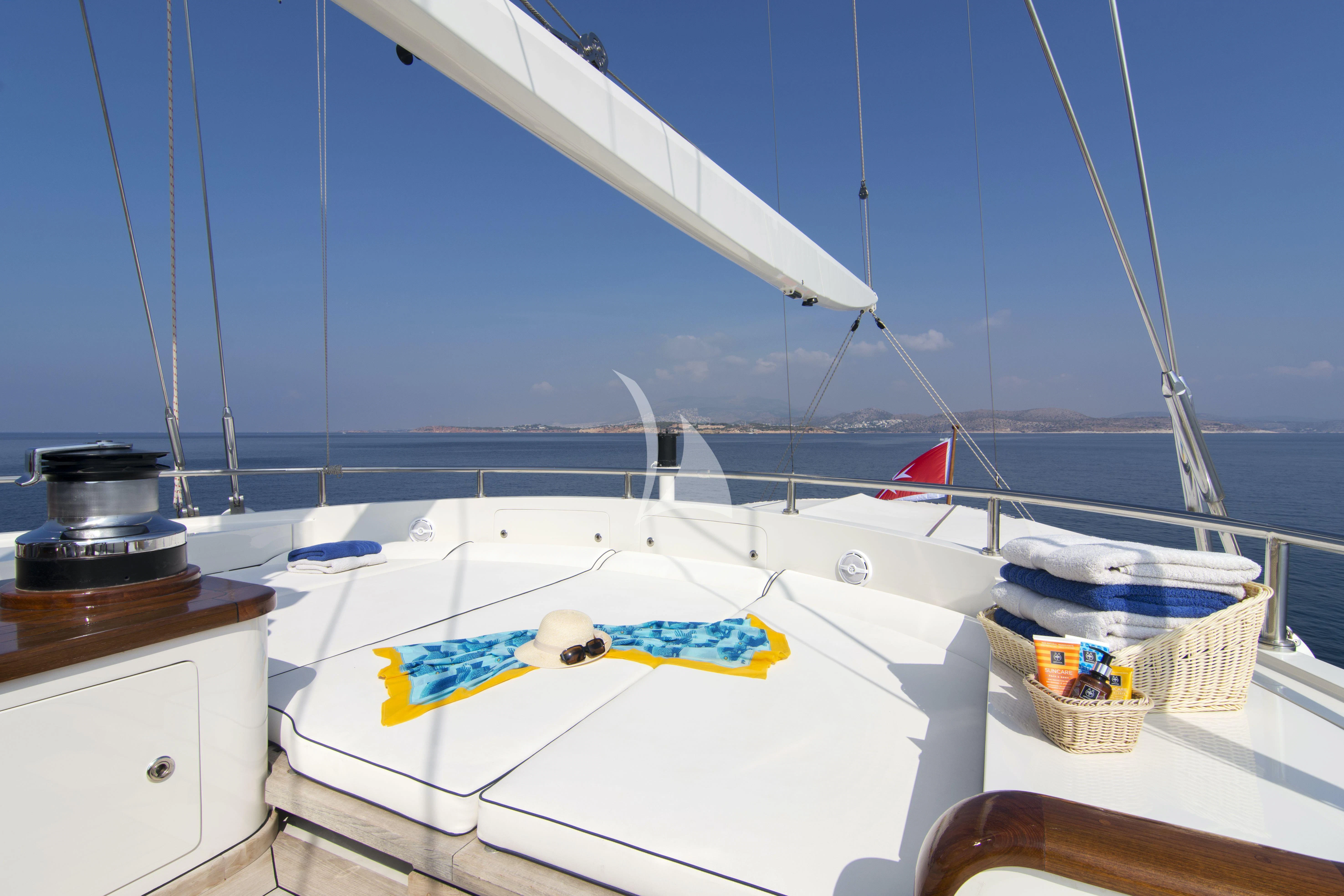 a white boat with a yellow sail on the water aboard XASTERIA Yacht for Charter
