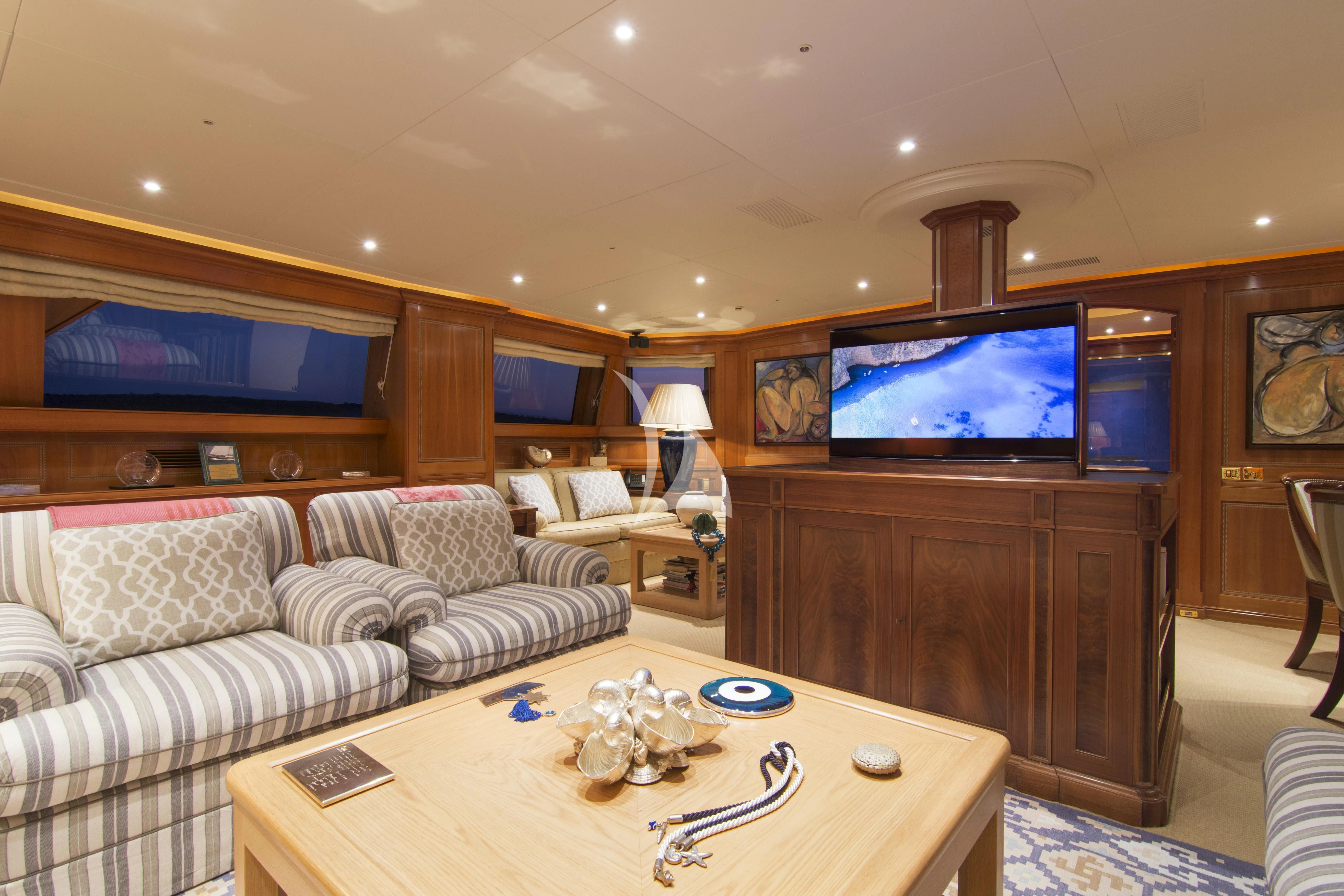 a living room with a tv and a table aboard XASTERIA Yacht for Charter