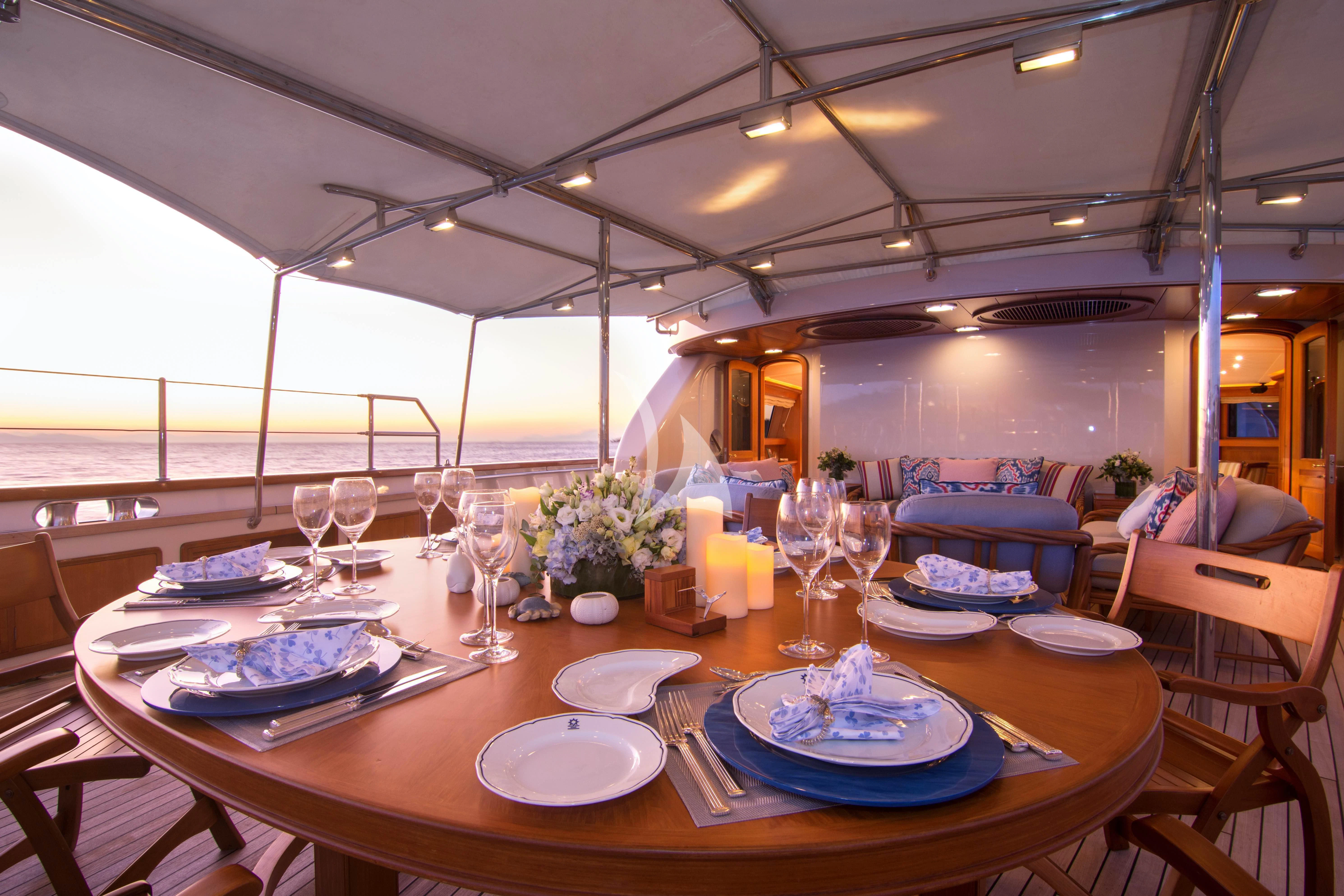 a table set with plates and glasses aboard XASTERIA Yacht for Charter
