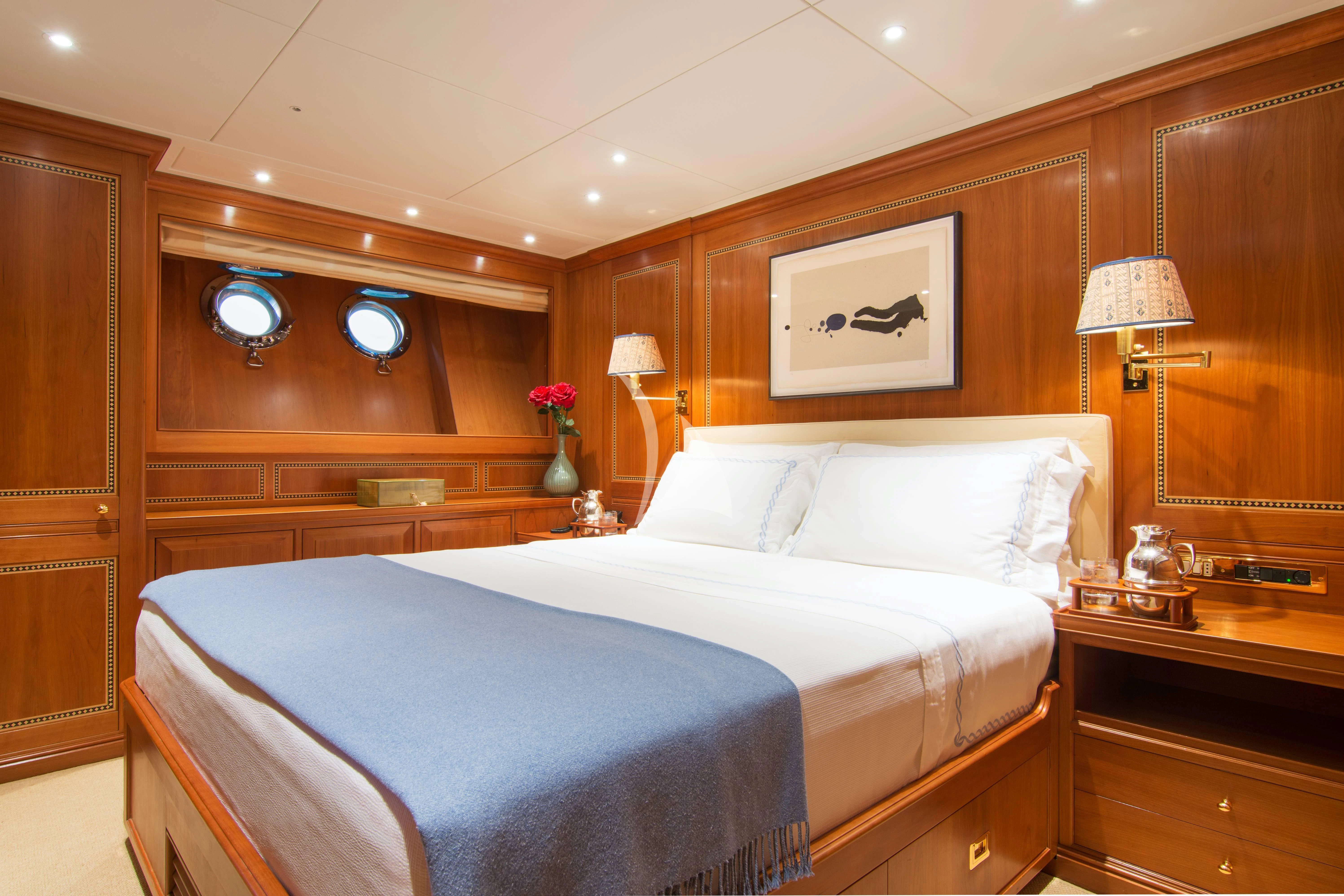 a bed with a blue sheet aboard XASTERIA Yacht for Charter