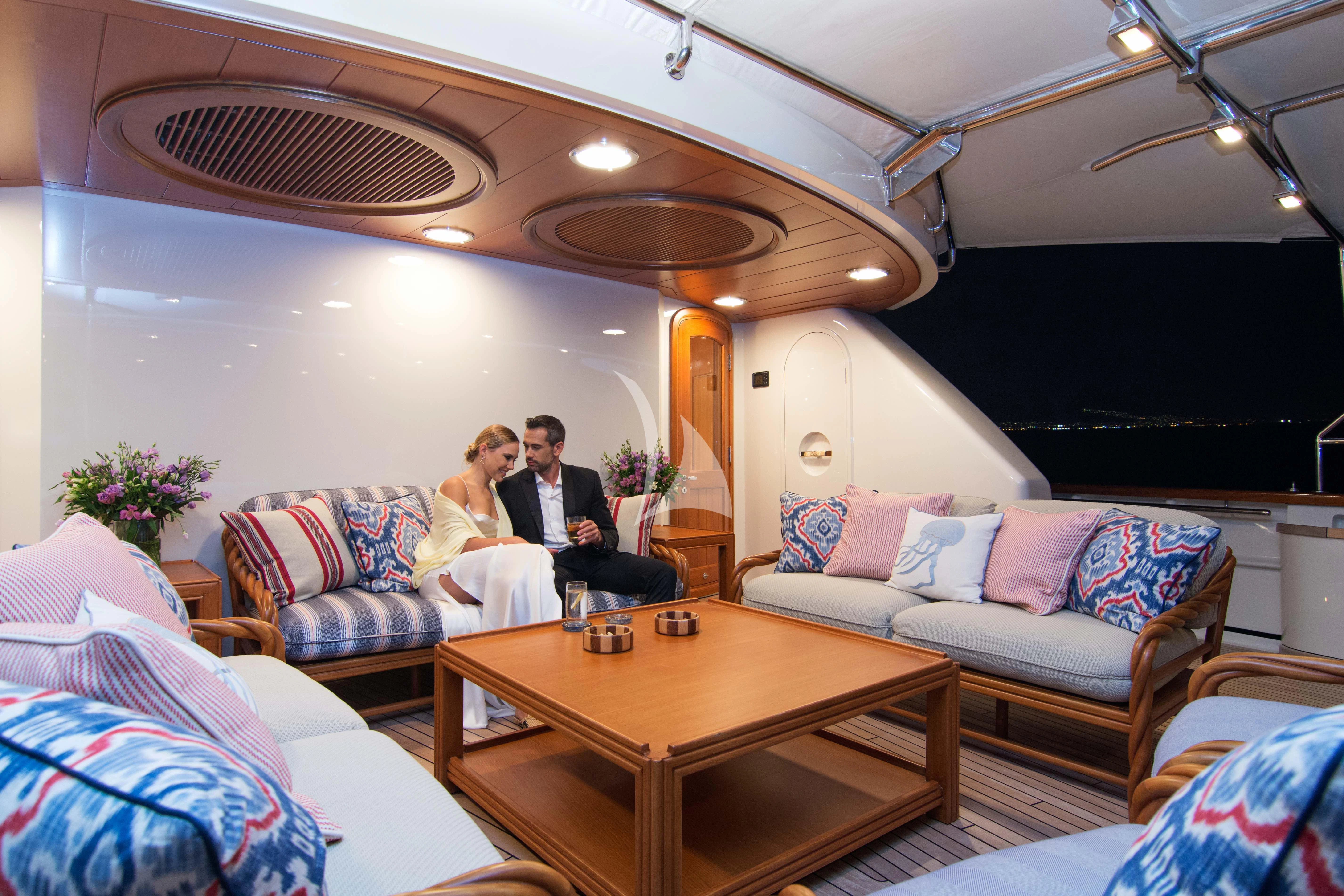 a couple sitting on a couch in a living room aboard XASTERIA Yacht for Charter