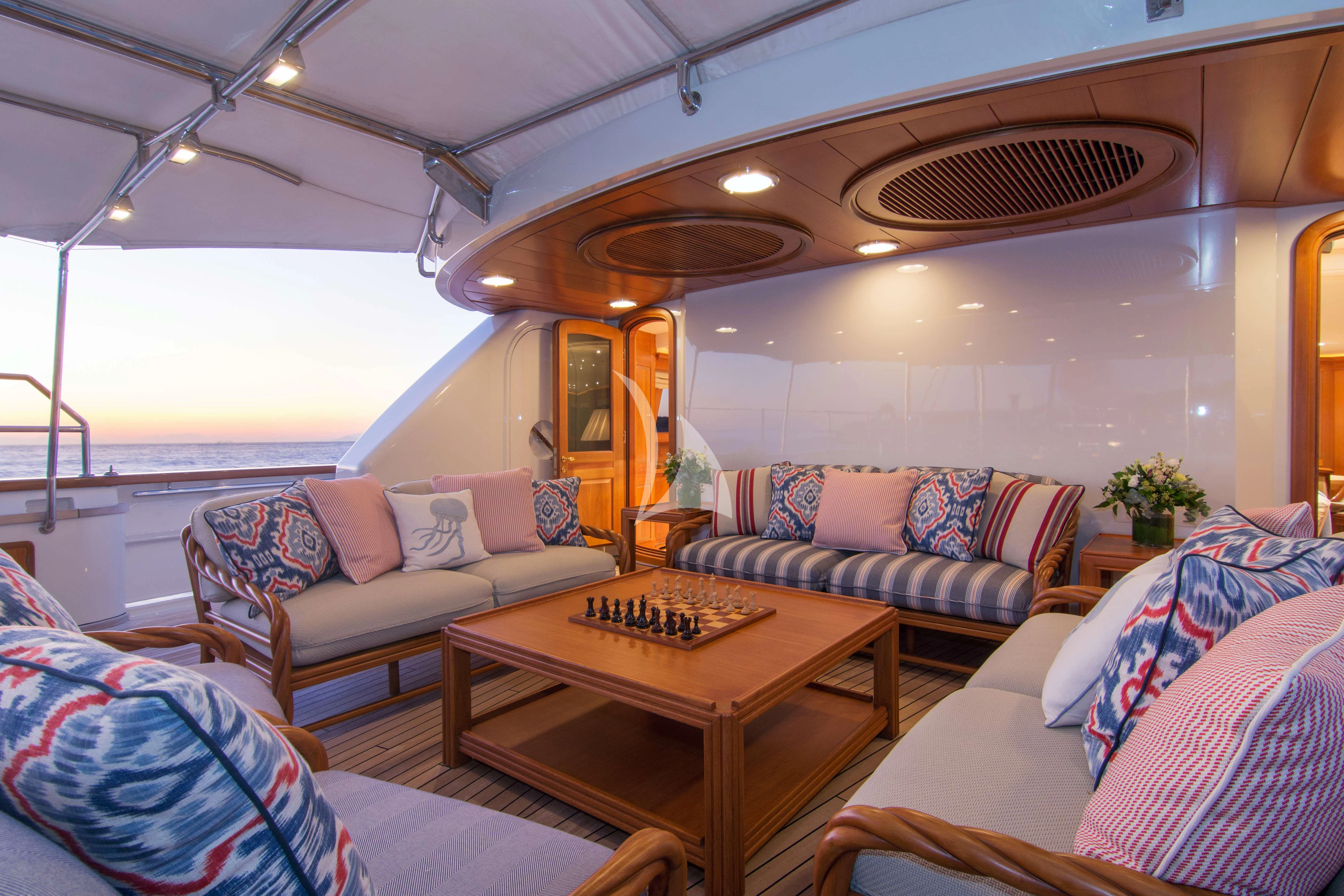 a living room with a table and couches aboard XASTERIA Yacht for Charter