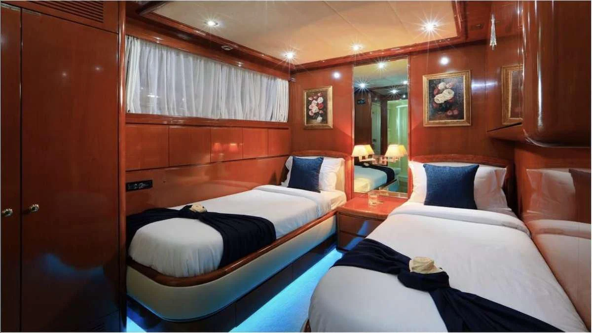 a room with beds and a mirror aboard DEMAREST Yacht for Sale