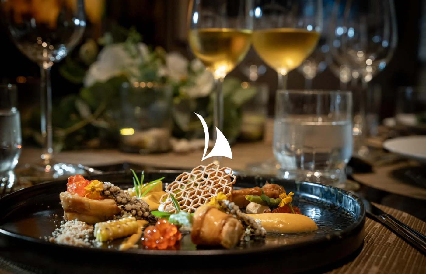 a plate of food and glasses of wine aboard ASAHI Yacht for Sale