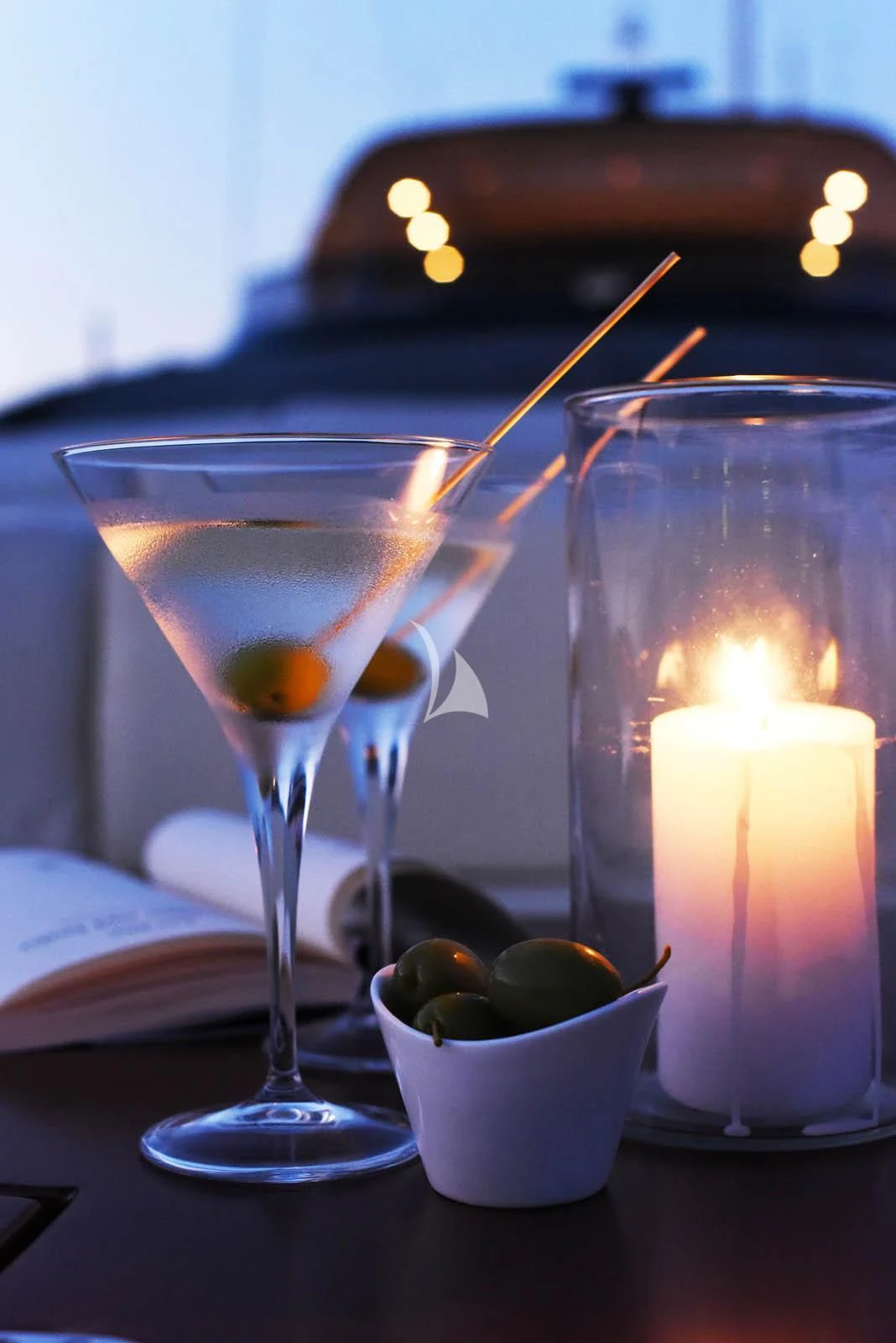 a couple of glasses with liquid in them next to a candle aboard ANYTHING GOES IV Yacht for Sale