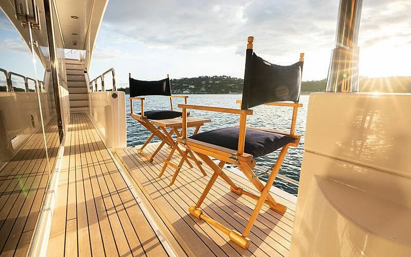 a deck with chairs and a table on it aboard R2 Yacht for Sale