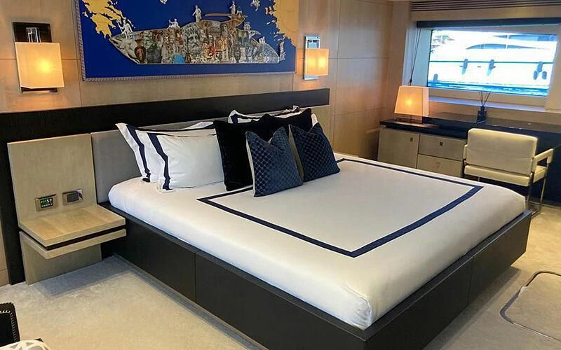a bed with a blue and white bed spread aboard R2 Yacht for Sale