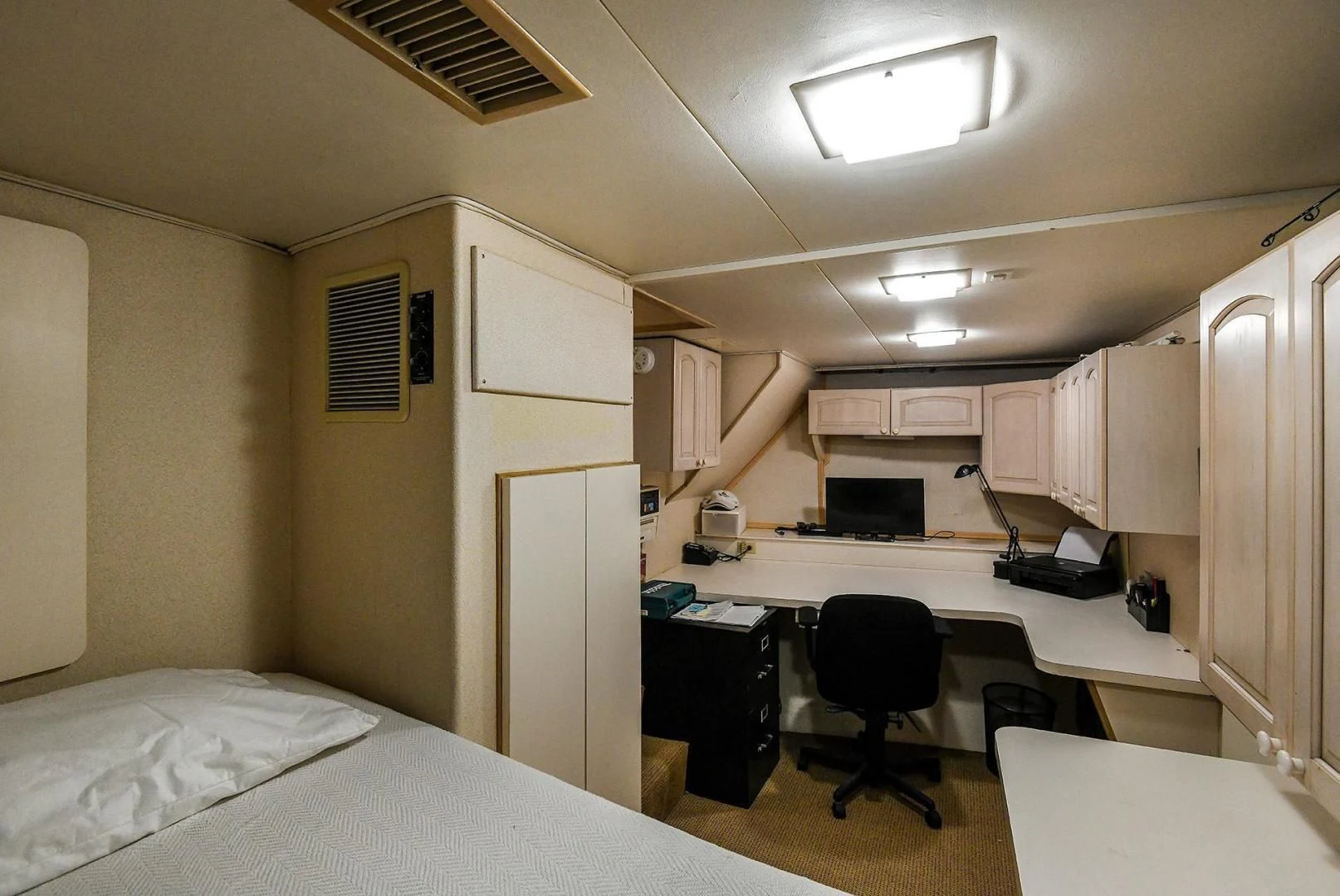 a bedroom with a bed and desk aboard PRIMETIME III Yacht for Sale
