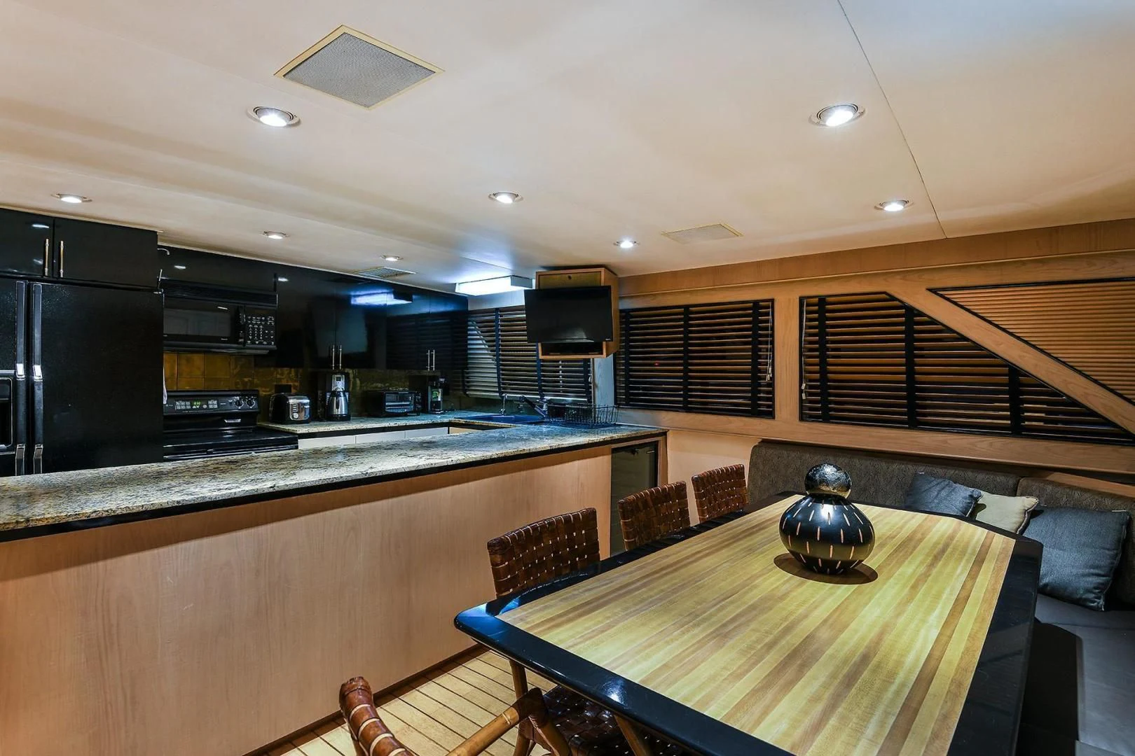a kitchen with a table and chairs aboard PRIMETIME III Yacht for Sale