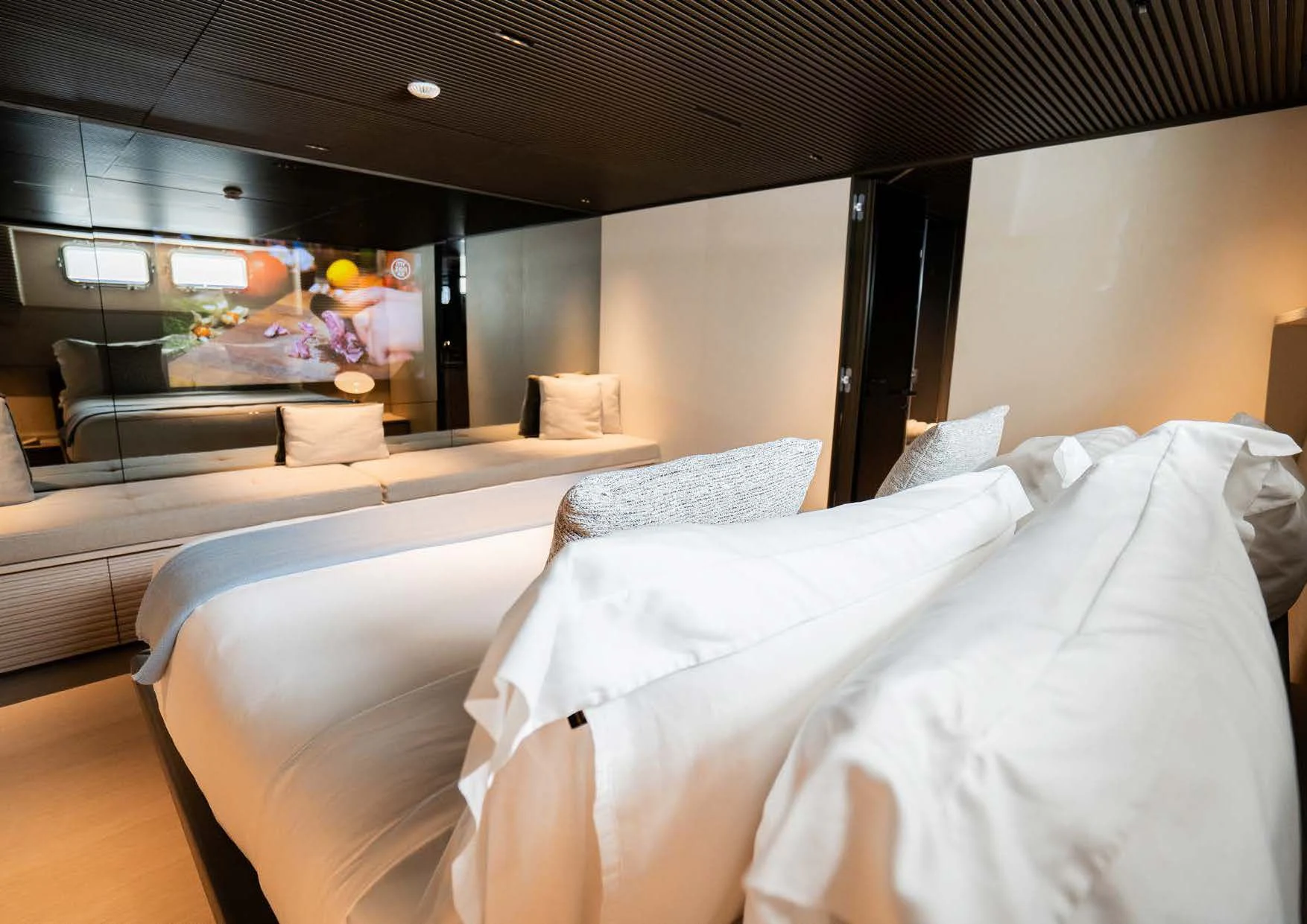 a room with a bed and a couch aboard ANMAX Yacht for Sale