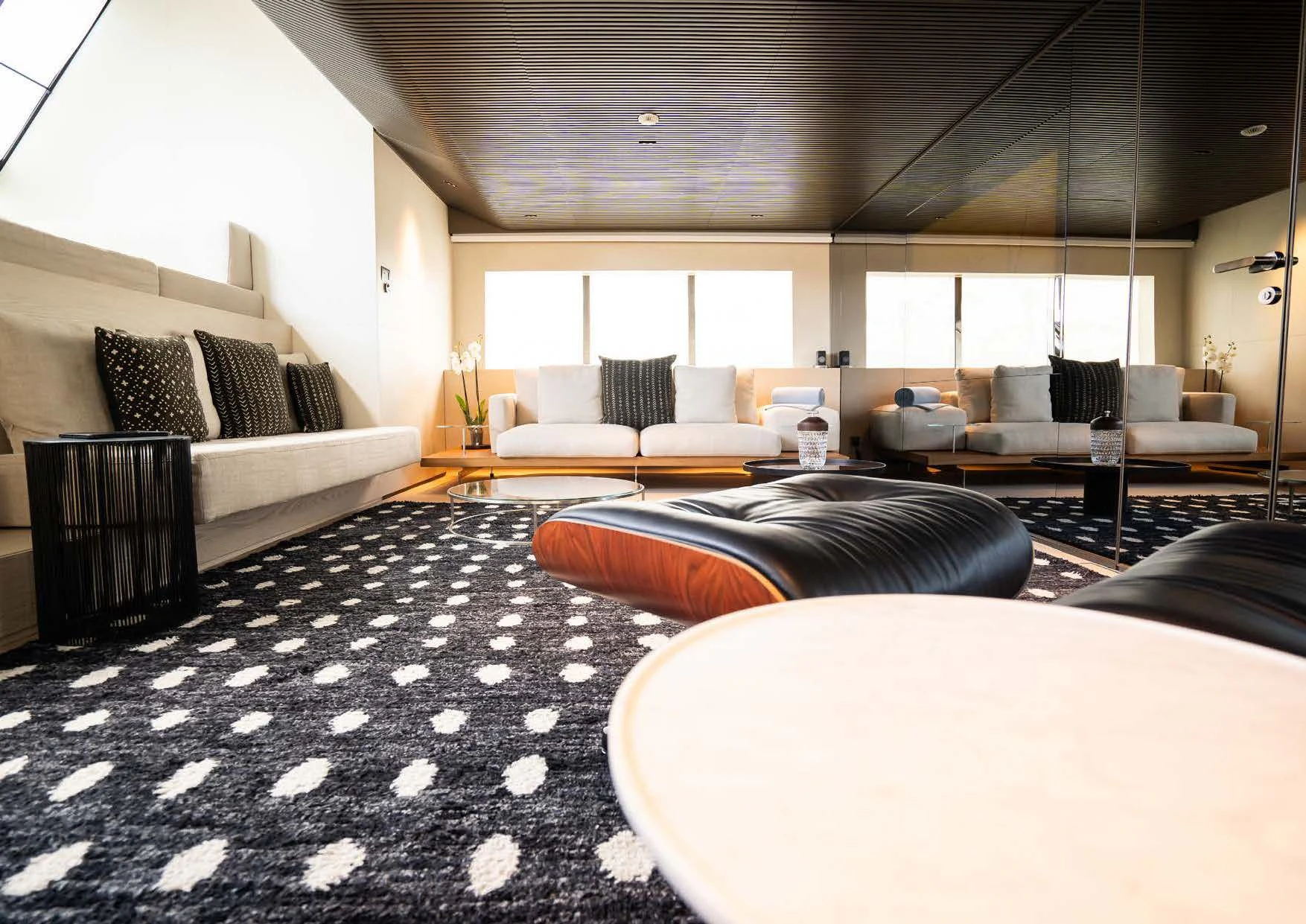 a large living room with white and black rugs aboard ANMAX Yacht for Sale