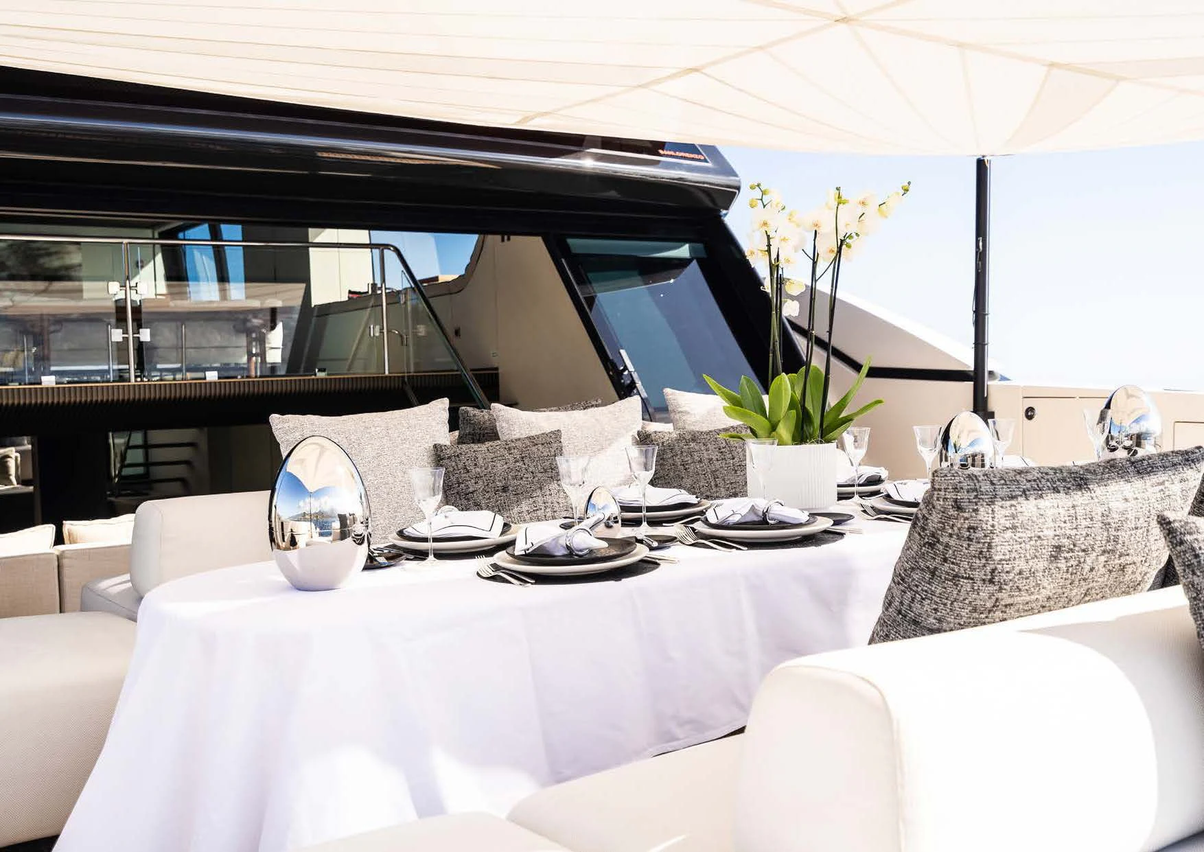 a table with a white tablecloth and white chairs with white cloths and a white tablecloth aboard ANMAX Yacht for Sale