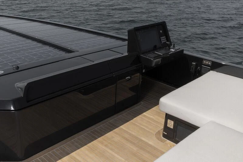 a black and white piano on a wooden deck next to a large body of water aboard ANMAX Yacht for Sale