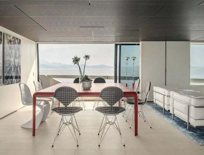a room with tables and chairs aboard ANMAX Yacht for Sale