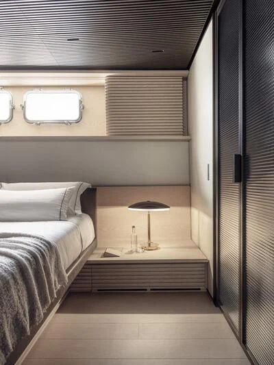 a room with a bed and a lamp aboard ANMAX Yacht for Sale