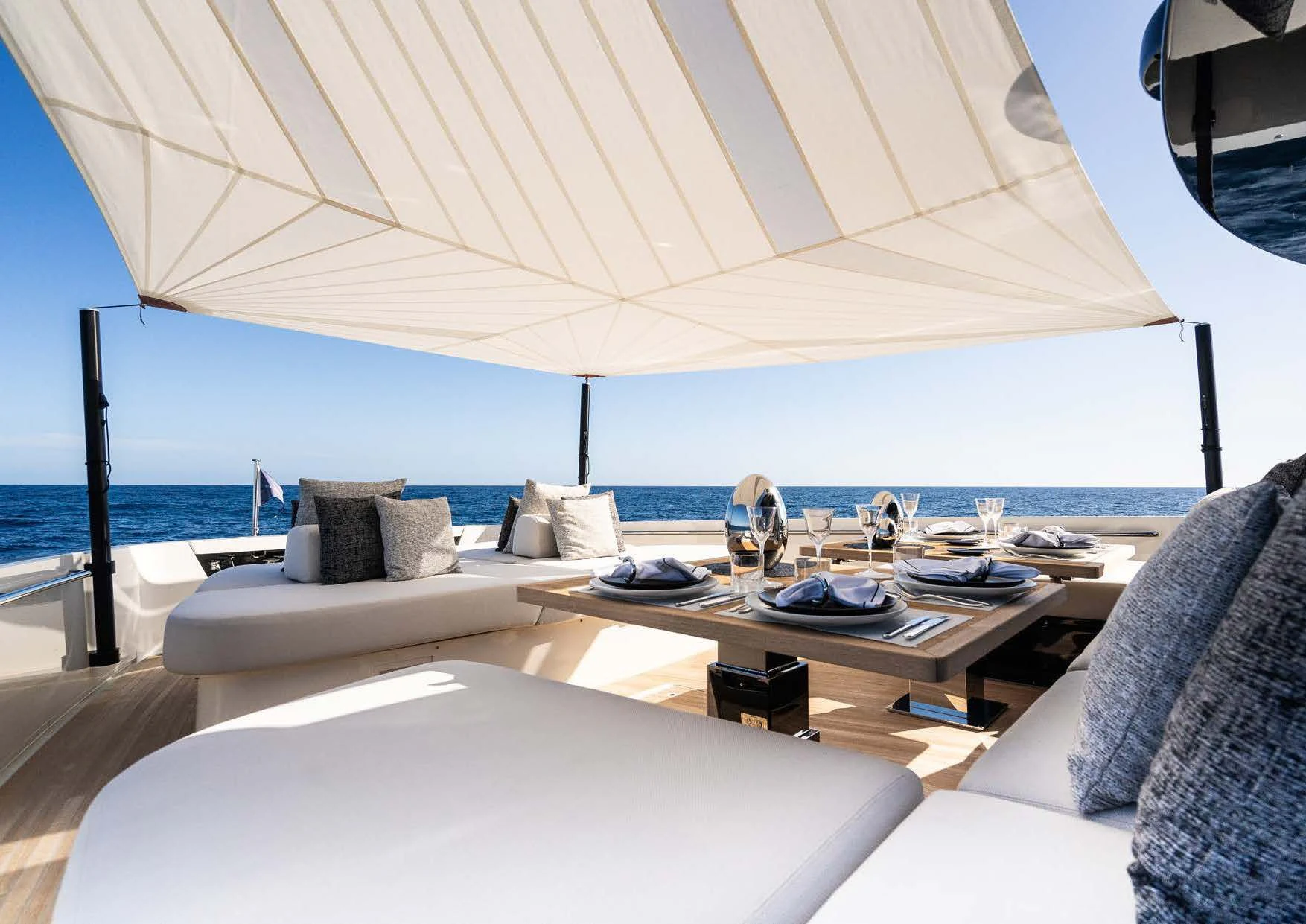 a large white lounge chair next to a large white sofa and a large white umbrella on a beach aboard ANMAX Yacht for Sale
