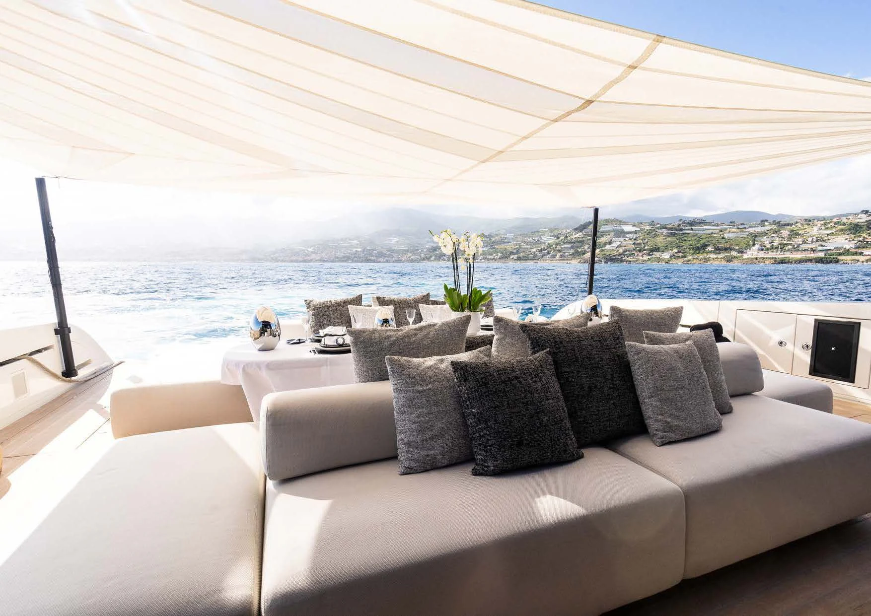 a couch with pillows and a table on it aboard ANMAX Yacht for Sale