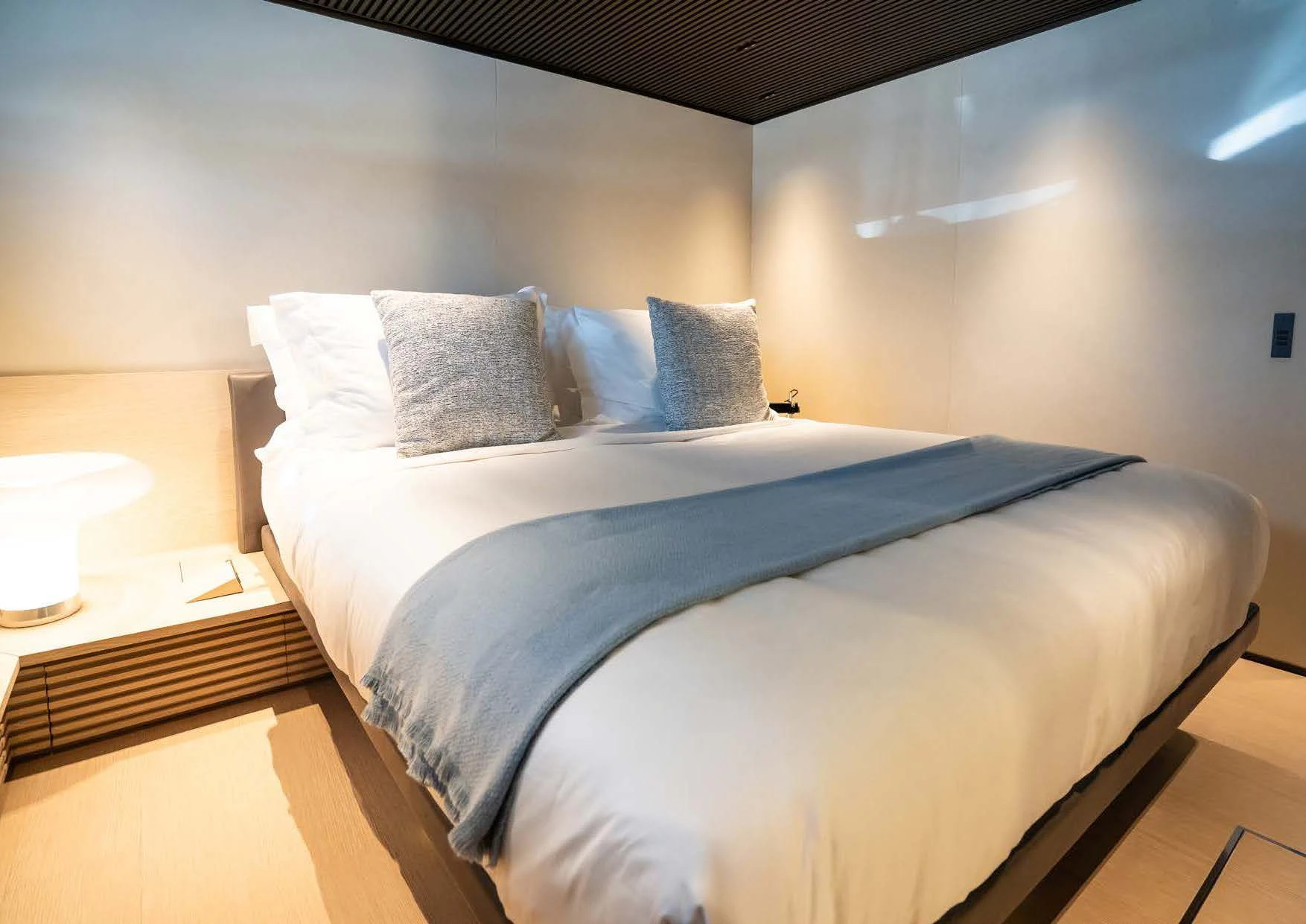 a bed with a blue comforter aboard ANMAX Yacht for Sale