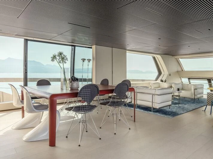 a room with tables and chairs aboard ANMAX Yacht for Sale