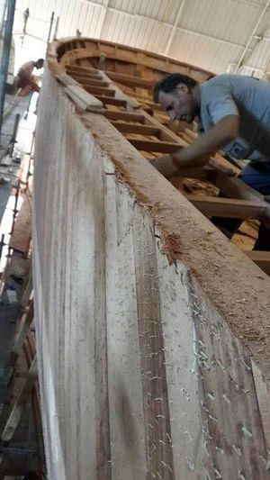 a person working on a wooden structure aboard VAGANTE Yacht for Sale