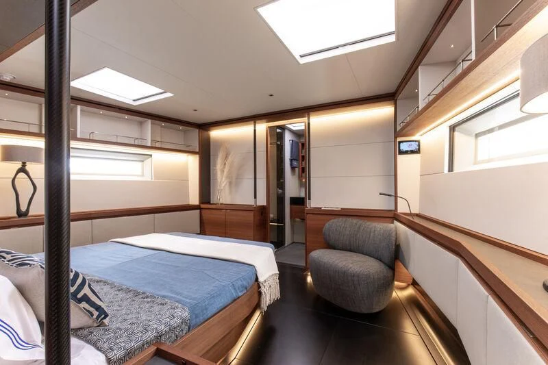 a room with a bed and a chair aboard NYUMBA GT Yacht for Sale