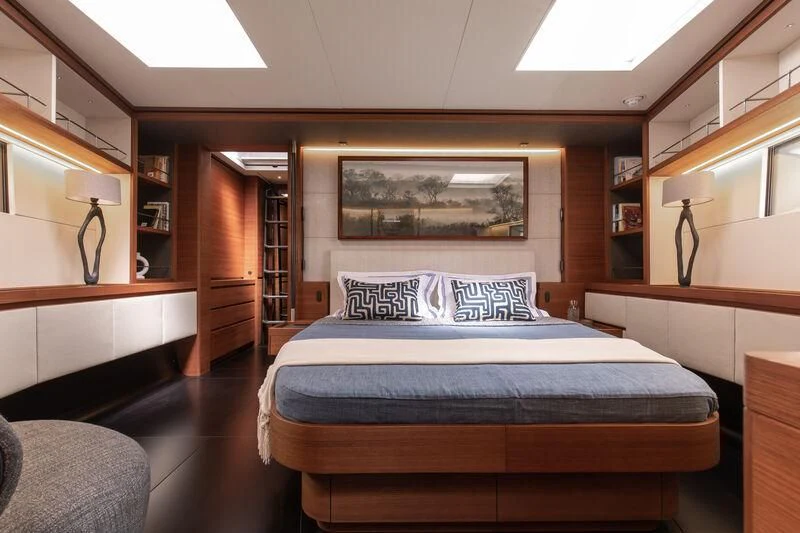 a bedroom with a bed and a desk aboard NYUMBA GT Yacht for Sale