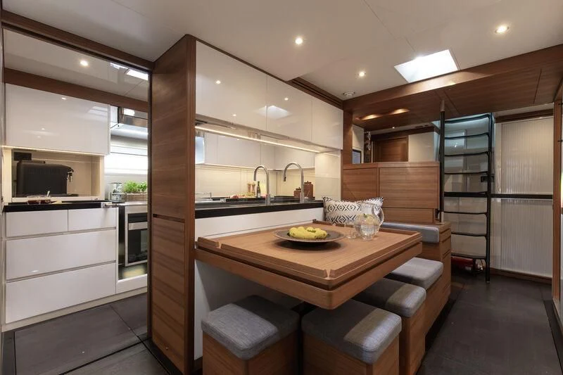 a kitchen with a table and chairs aboard NYUMBA GT Yacht for Sale