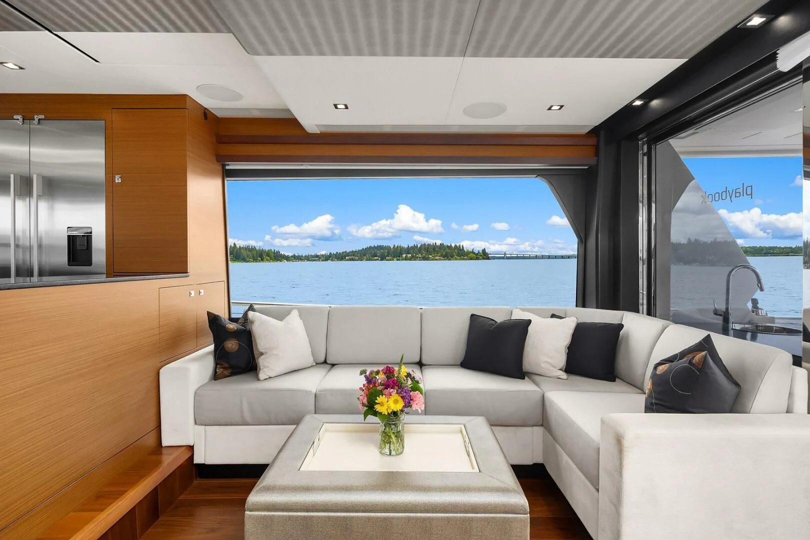 a room with a couch and a table with a vase of flowers on it aboard PLAYBOOK Yacht for Sale