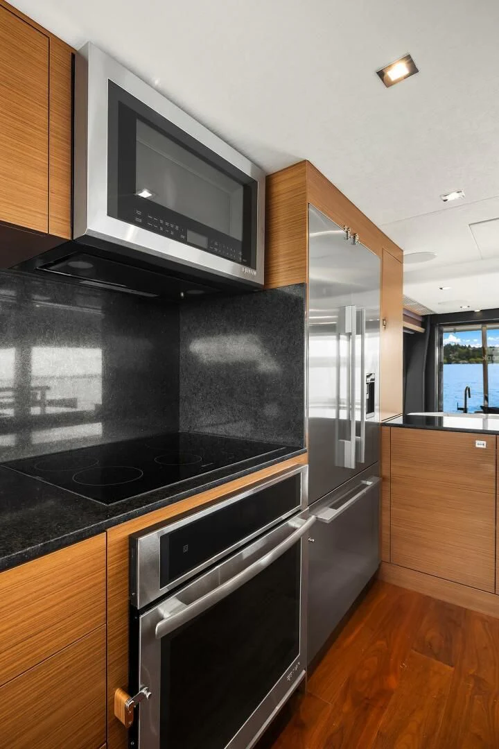 a kitchen with a black stove and a microwave aboard PLAYBOOK Yacht for Sale