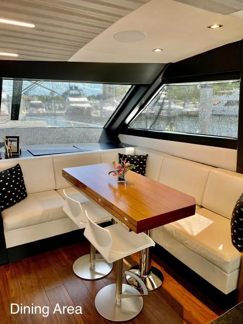 a room with a table and chairs aboard PLAYBOOK Yacht for Sale