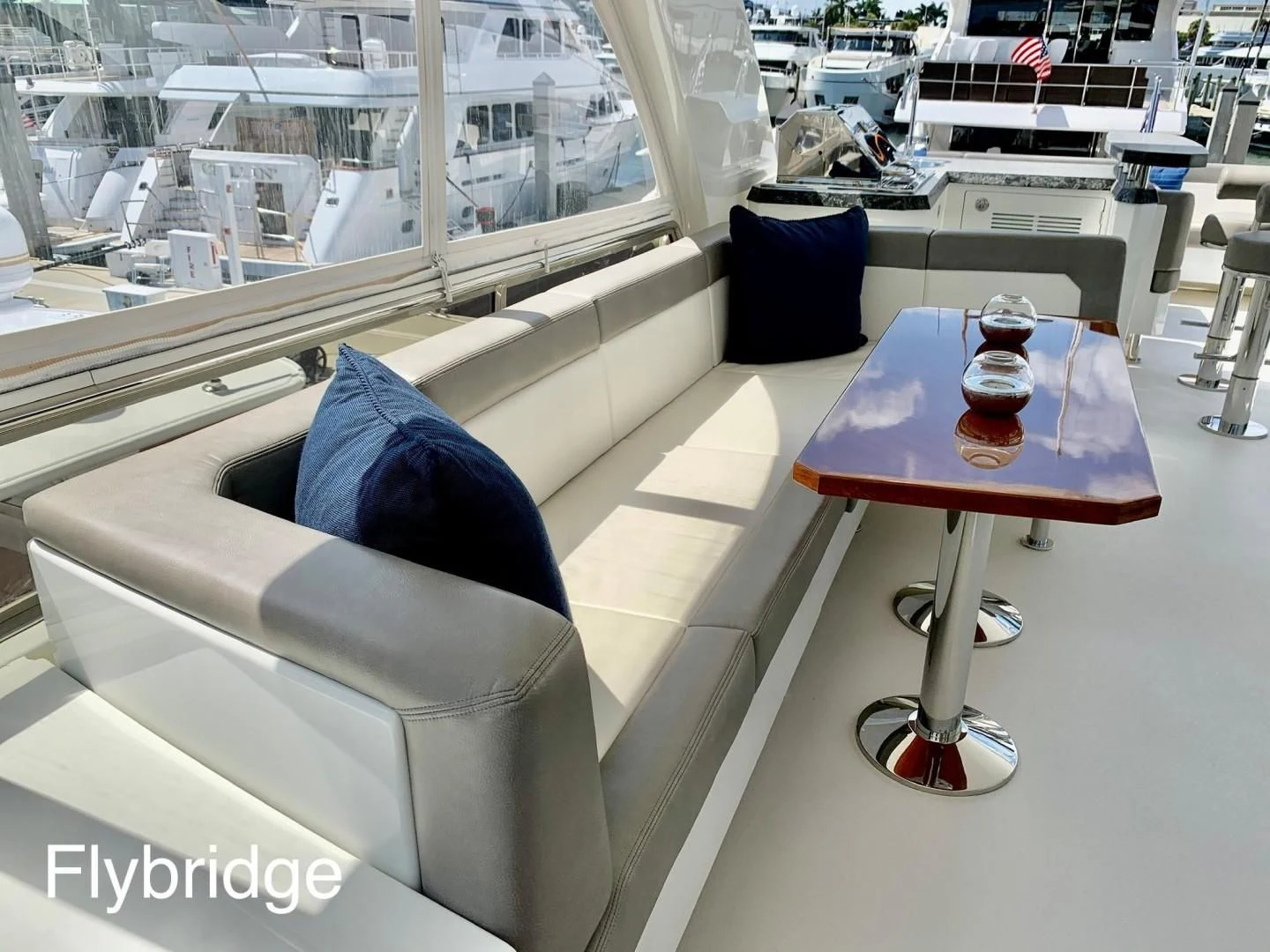 a table with a chair and a couch in a room with a window aboard PLAYBOOK Yacht for Sale