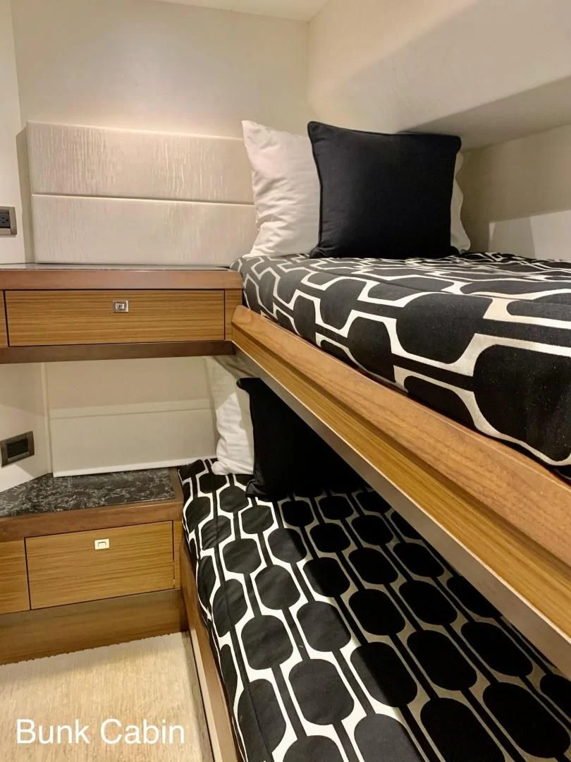 a bed with a black and white checkered blanket aboard PLAYBOOK Yacht for Sale