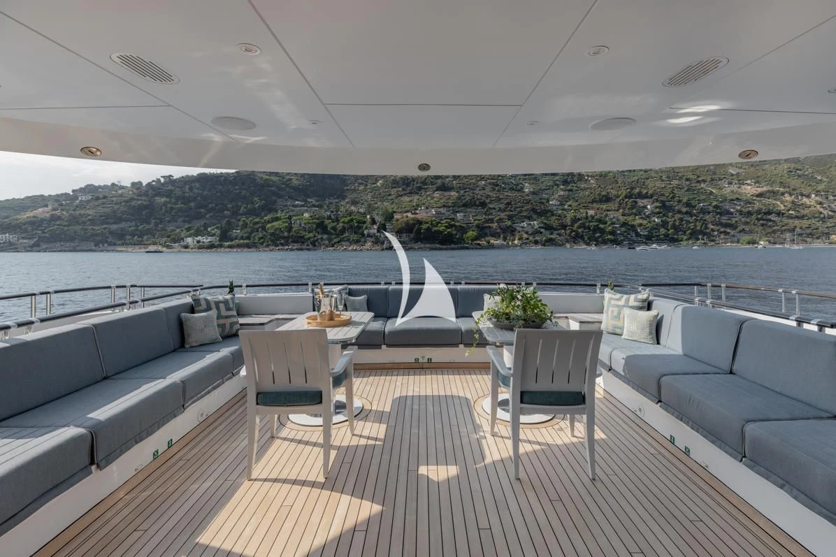 a deck with a table chairs and a view of a city aboard IDEFIX II Yacht for Charter