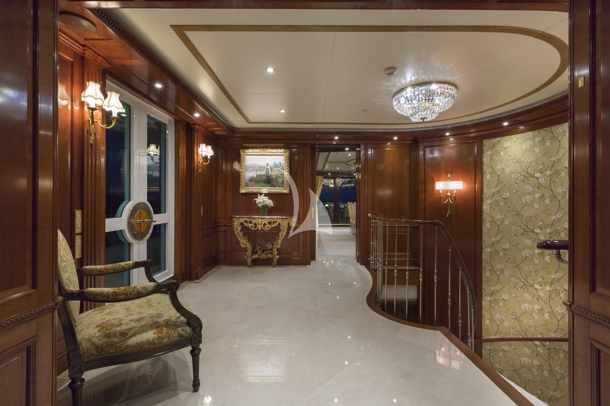 a hallway with a chandelier and a chair aboard KATHARINE Yacht for Sale