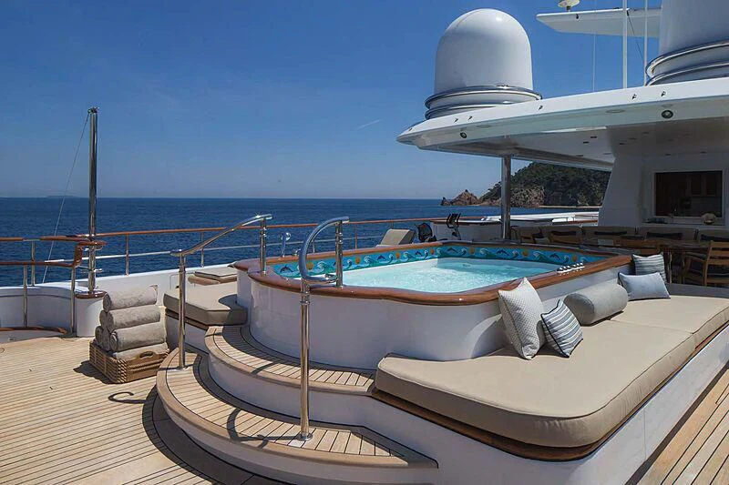 a deck with a pool and a large white building on the side aboard KATHARINE Yacht for Sale