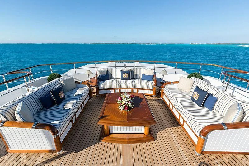a deck with chairs and tables on it by the ocean aboard KATHARINE Yacht for Sale
