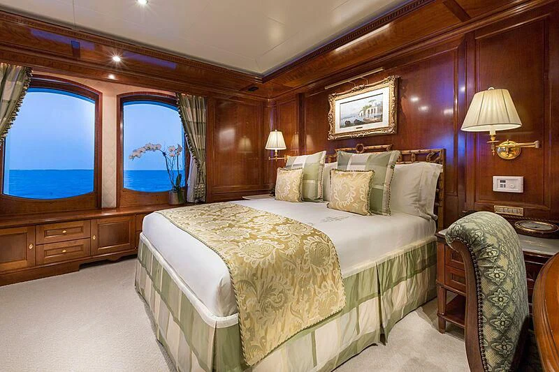 a bedroom with a bed and a chair aboard KATHARINE Yacht for Sale