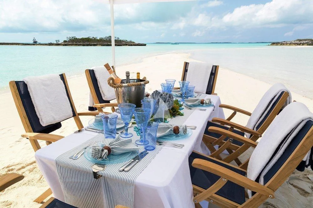 a table set for a dinner on a beach aboard KATHARINE Yacht for Sale