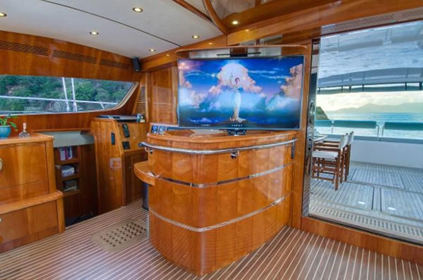 a room with a tv and a wood cabinet aboard 74' PRIVILEGE 2010 Yacht for Sale