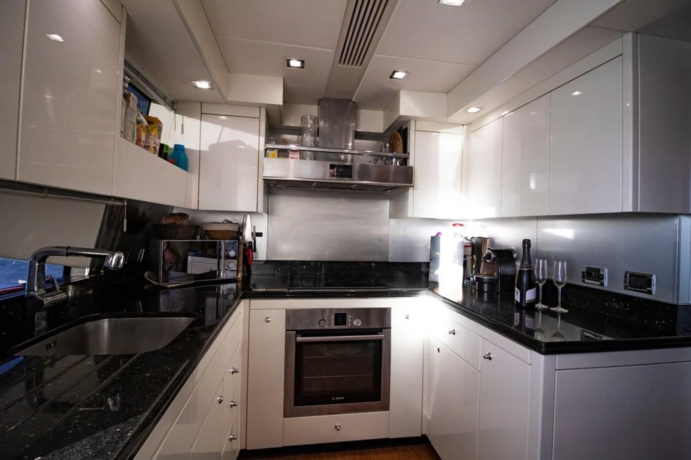 a kitchen with white cabinets aboard LI-JOR Yacht for Sale