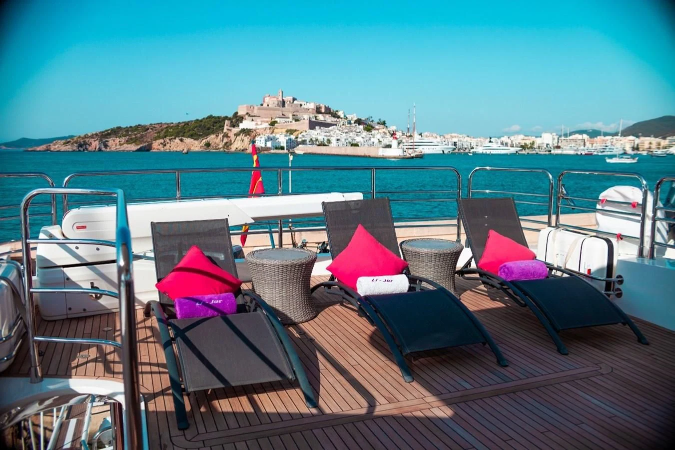 a deck with chairs and umbrellas on it by the water aboard LI-JOR Yacht for Sale