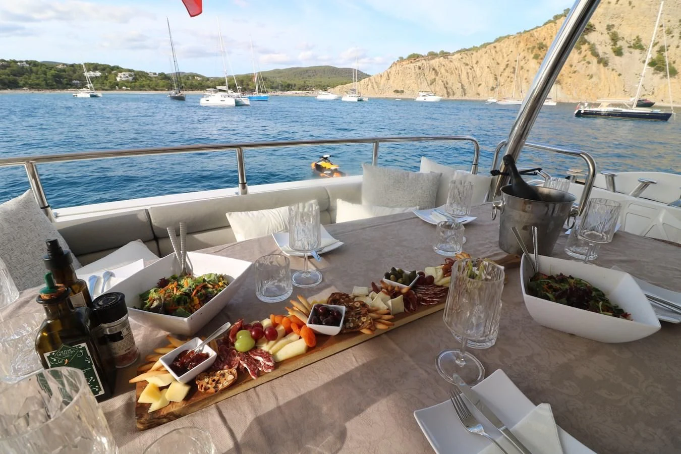 a table with food and wine bottles on it aboard LI-JOR Yacht for Sale