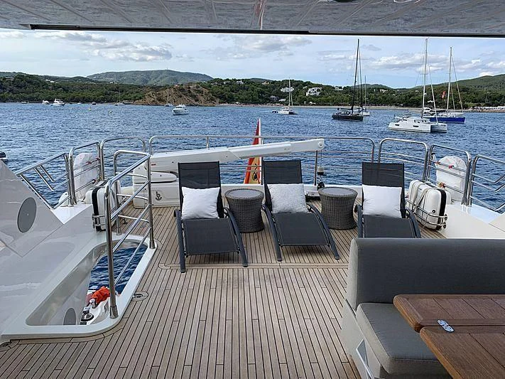 a deck with chairs and tables on it by the water aboard LI-JOR Yacht for Sale