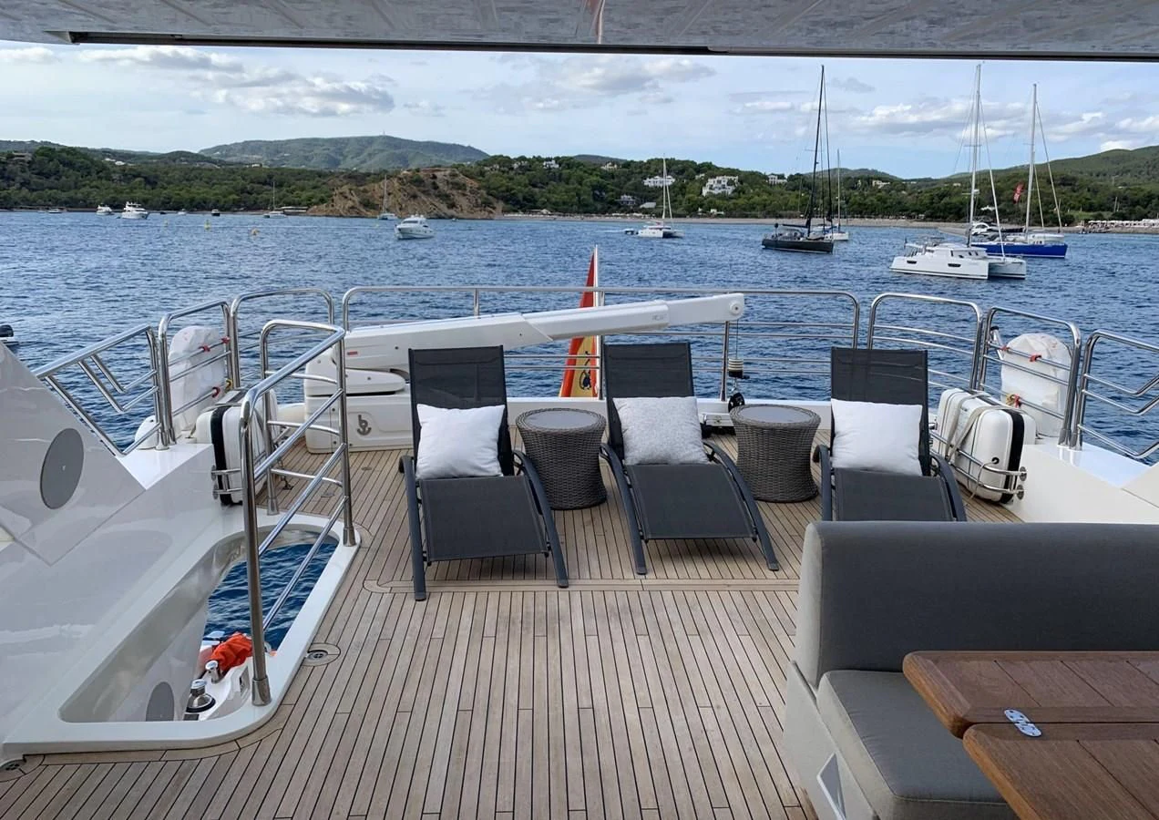 a deck with chairs and tables on it by the water aboard LI-JOR Yacht for Sale